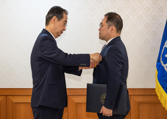 =한덕수 국무총리가 24일 오전 서울 종로구 정부서울청사에서 열린 정부 업무평가 유공자 포상 수여식에 참석해 박진홍 국토교통부 과장에게 녹조 근정훈장을 수여하고 있다. [연합뉴스]